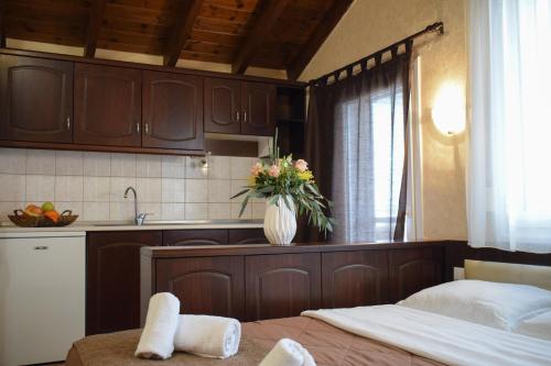 a kitchen with a bed and a vase of flowers at Filippion Hotel in Keramotí