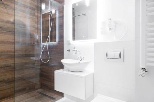 biała łazienka z umywalką i prysznicem w obiekcie HOUSEHOST Apartment: Miodowa 42/8a Street w Krakowie