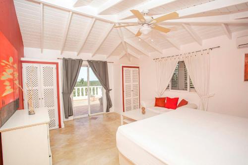 a bedroom with a white bed and a ceiling fan at Lutix Village in Santa Bárbara de Samaná