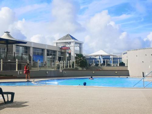 a person standing near a swimming pool in a building at The Abi Joseph @Combe Haven in Hastings
