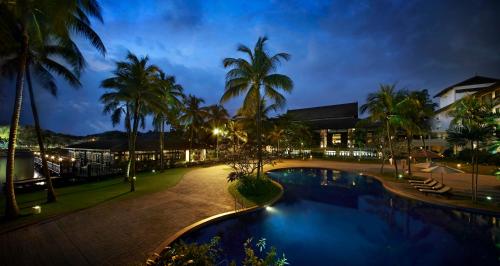 uma vista para uma piscina de resort à noite em The Saujana Kuala Lumpur em Subang Jaya