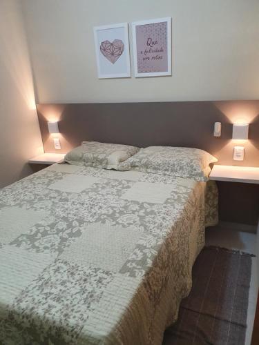 een bed in een slaapkamer met twee lampen en twee foto's aan de muur bij Winterville Resort Flat 910 Gravatá-Pe in Gravatá