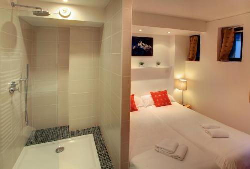 a small bathroom with a bed and a shower at Les Campanules in Les Houches