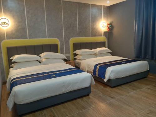 two beds sitting next to each other in a room at GOOD 9 HOTEL - Cahaya Kota Puteri in Pasir Gudang