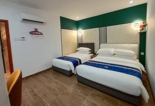 a hotel room with two beds in it at GOOD 9 HOTEL - Cahaya Kota Puteri in Pasir Gudang