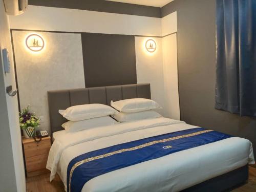 a bedroom with a large bed with white sheets and pillows at GOOD 9 HOTEL - Cahaya Kota Puteri in Pasir Gudang