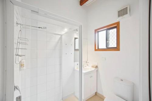 a white bathroom with a shower and a sink at ELM Accommodation - Merrijig in Merrijig