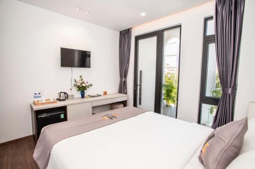 a bedroom with a white bed and a window at Nile Hotel in Tuy Hoa