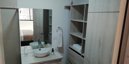 a bathroom with a sink and a mirror at HERMOSO Apartamento Ibague 301 F1 in Ibagué