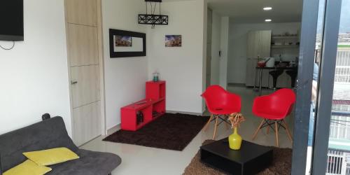 a living room with a couch and red chairs at HERMOSO Apartamento Ibague 301 F1 in Ibagué