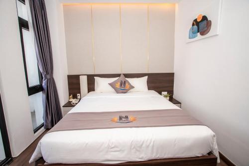 a bedroom with a large white bed with two pillows at Nile Hotel in Tuy Hoa