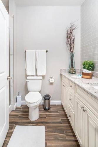 a white bathroom with a toilet and a sink at Gorgeous Cades Cove Condo with Community Pool in Townsend