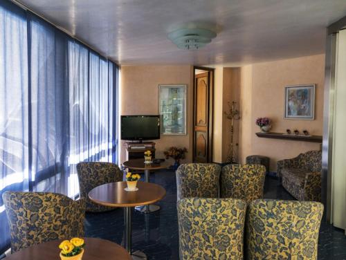 una camera d'albergo con sedie, tavolo e televisore di Hotel Fabius a Bellaria-Igea Marina