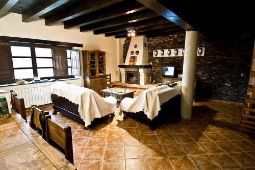 sala de estar con 2 camas y chimenea en Casa Rural Aquilamas en La Bastida