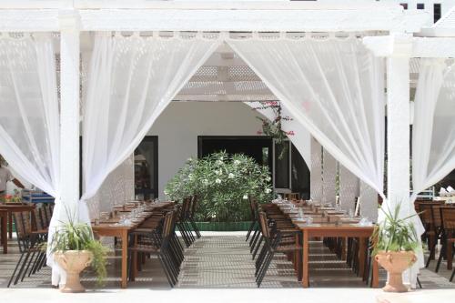 a set up for a wedding with wooden tables and white curtains at Seabel Aladin Djerba in Aghīr