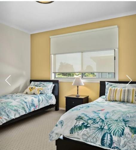 a bedroom with two beds and a window at Redwood Delight in Cowes