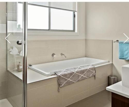 a bath tub in a bathroom with a window at Redwood Delight in Cowes