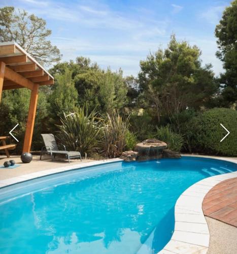 a swimming pool with a patio and a pergola at Redwood Delight in Cowes