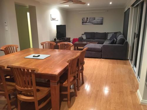 a living room with a table and chairs and a couch at Waterside Canal Dreams in Mandurah
