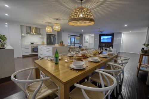 a dining room with a table and chairs and a kitchen at Hidden Oasis - Peregian Beach in Peregian Beach