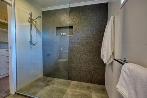 a bathroom with a shower with a glass door at Hidden Oasis - Peregian Beach in Peregian Beach