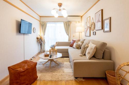 a living room with a couch and a table at Type C Room 40平米 -ウル エスポワール那覇- in Kume