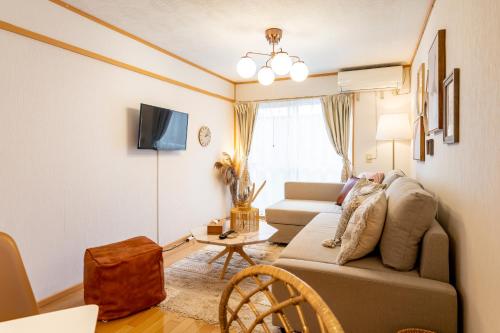 a living room with a couch and a table at Type C Room 40平米 -ウル エスポワール那覇- in Kume