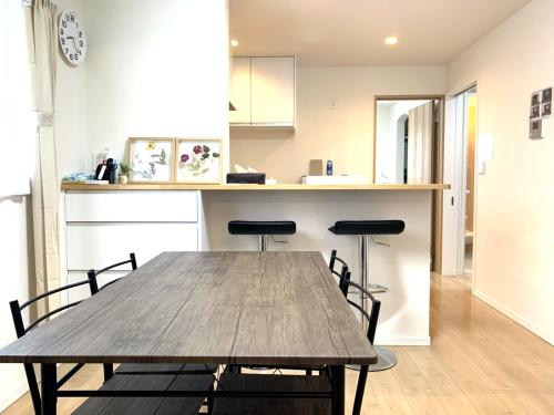 eine Küche mit einem Holztisch und 2 Stühlen in der Unterkunft Guesthouse徳島201 in Tokushima