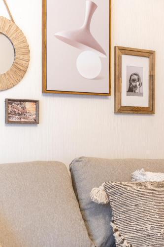 a living room with a couch and pictures on the wall at Type C Room 40平米 -ウル エスポワール那覇- in Kume