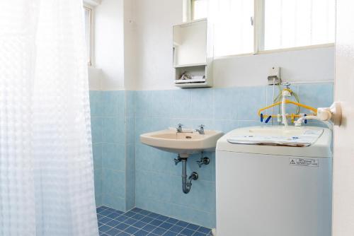 Un baño azul con lavabo y lavabo. en Type C Room 40平米 -ウル エスポワール那覇- en Kume