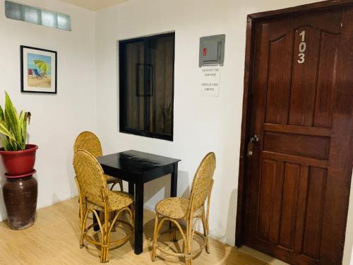 een kamer met een tafel en stoelen en een deur bij Anang Balay Turista in El Nido
