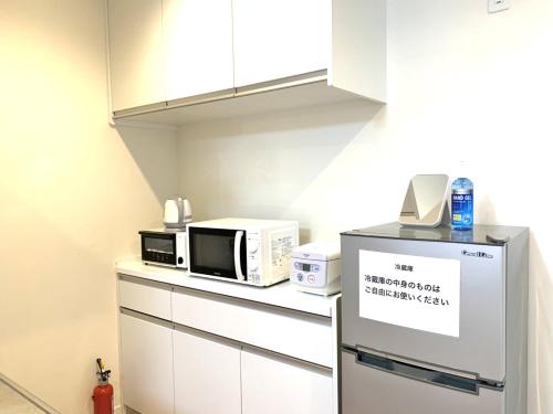 a kitchen with two microwaves and a microwave on a counter at Guesthouse徳島201 in Tokushima