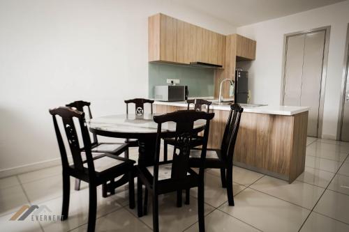 a kitchen with a table and chairs in a room at Marina Times Square Homestay by Evernent in Miri