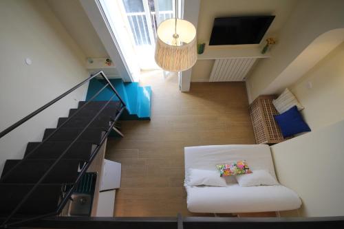 ein Wohnzimmer mit einer weißen Couch und einer Treppe in der Unterkunft Albachiara in Neapel