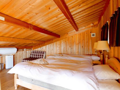 a bedroom with a large bed in a wooden ceiling at Mt Ichibata Cottage in Izumo