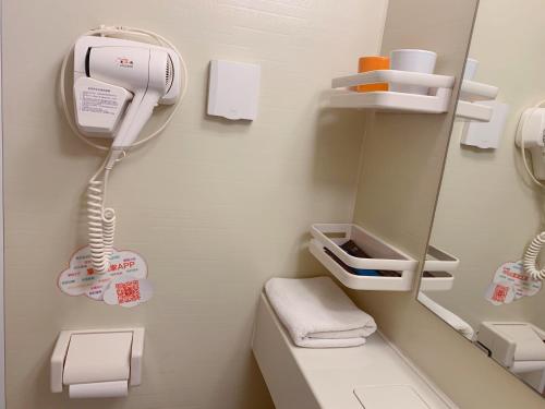 a hospital room with a phone and a mirror at Home Inn Mianyang People'S Park in Mianyang