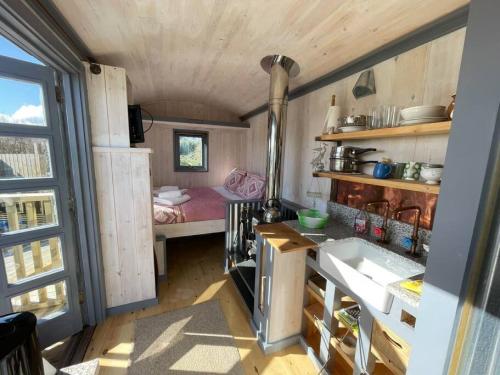 a kitchen with a sink and a room with a bed at Hidden Hut Secluded Shepherds Hut Titagel in Tintagel