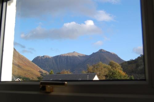 a view of a mountain range from a window at Duart Cottage in Glencoe