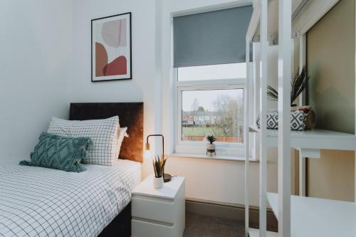 um quarto com uma cama e uma janela em ENTIRE HOUSE WITH PARKING IN RUGBY em Rugby