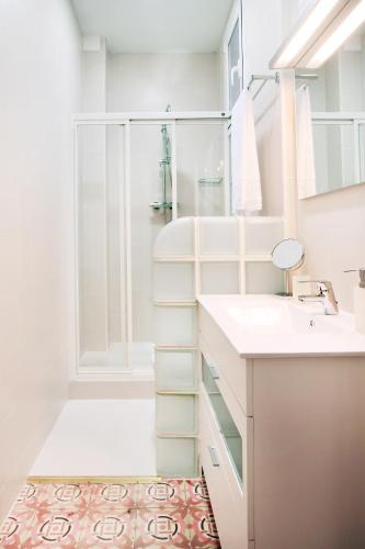 a white bathroom with a shower and a sink at Casa Valeta in Barcelona