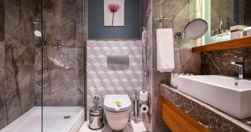 a bathroom with a toilet and a sink and a shower at Baia Lara Hotel in Lara