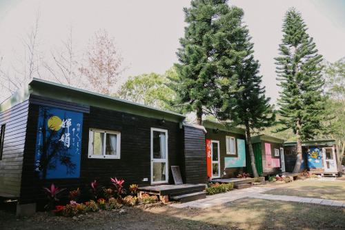 Une rangée de petites maisons avec des arbres en arrière-plan dans l'établissement 山板樵愛面子民宿, à Sanyi