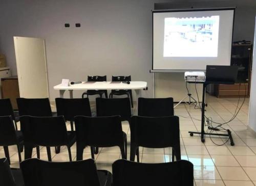 a room with a table and chairs and a projection screen at Twelve Hotel in Moncalieri