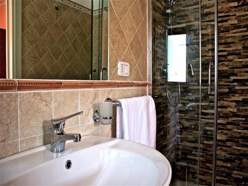 y baño con lavabo, espejo y ducha. en Liseda, en Castellabate