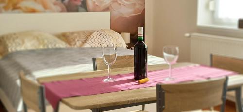 a bottle of wine sitting on a table with two glasses at La Siesta Bogács Apartman in Bogács