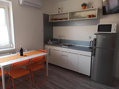 a kitchen with a table and a refrigerator at La Siesta Bogács Apartman in Bogács