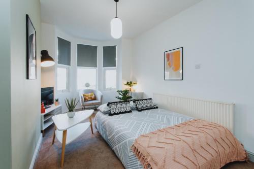 a bedroom with a bed and a table and a chair at BRAND NEW TOWNHOUSE IN RUGBY in Rugby