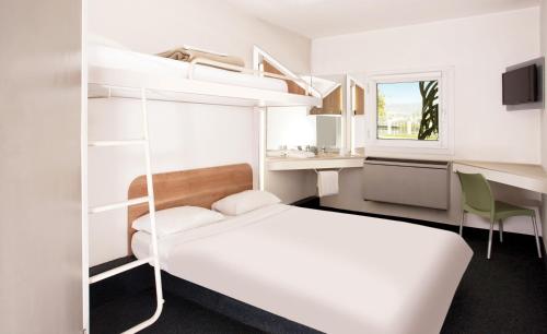 SUN1 Richards Bay في خليج ريتشاردز: غرفة نوم بسرير ومكتب وسرير بطابقين