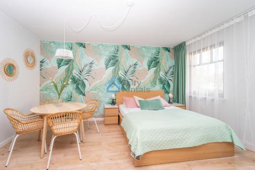 um quarto com uma cama e uma mesa em Botanika Deluxe Apartment Sopot em Sopot