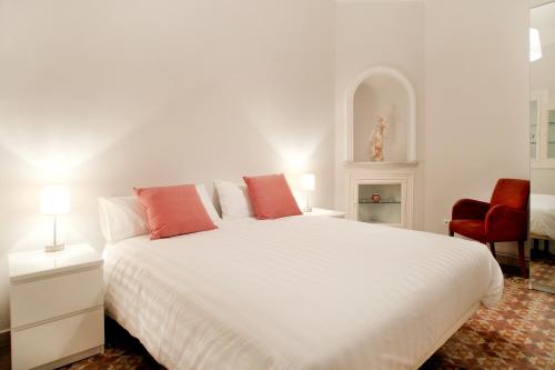 a bedroom with a large white bed with red pillows at Casa Valeta in Barcelona